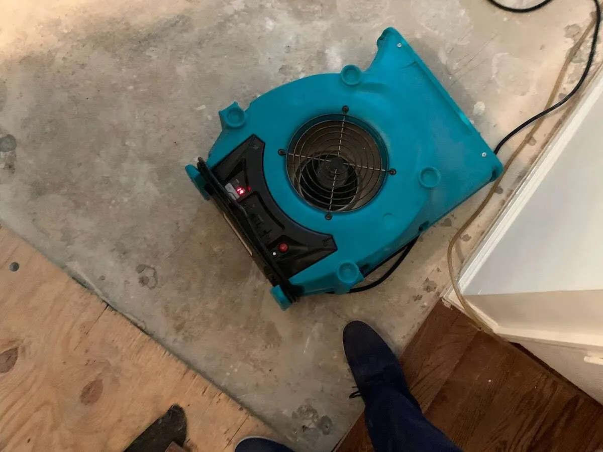 Air mover drying subfloor during Commercial Water Damage Restoration in Elgin